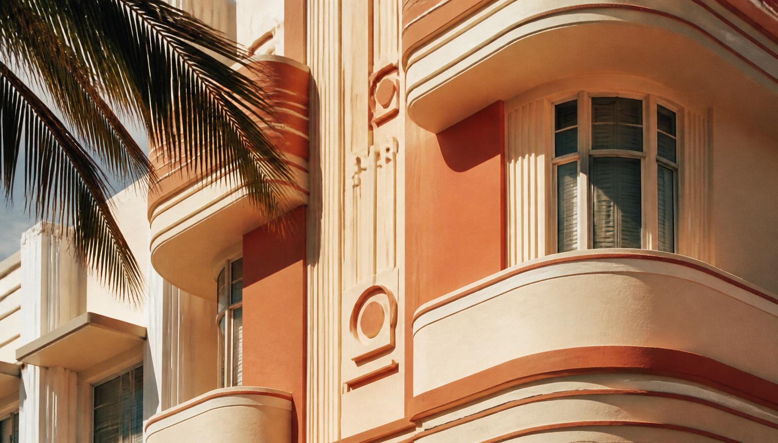 Art Deco hotel facade with curved balconies and palm fronds